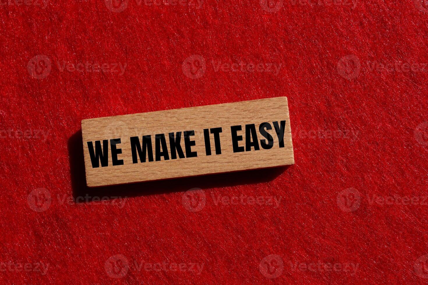 We make it easy message written on wooden block with red felt background. Conceptual we make it easy symbol. Copy space. photo
