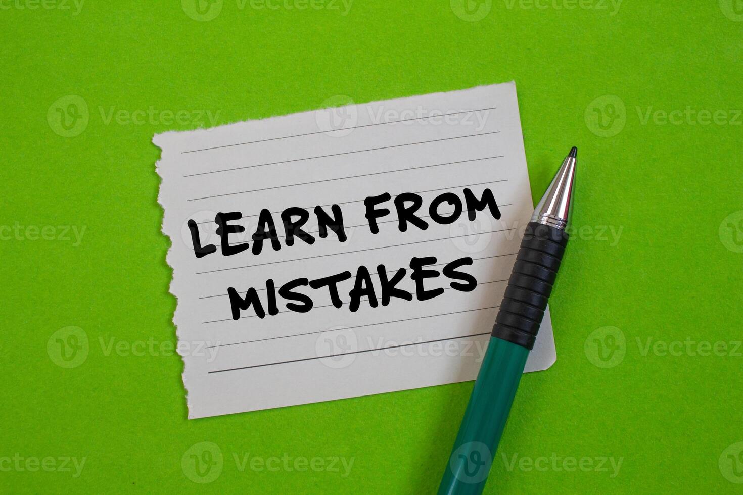 Learn from mistakes message written on ripped torn paper with a pen on green background. Conceptual learn from mistakes symbol. Copy space. photo