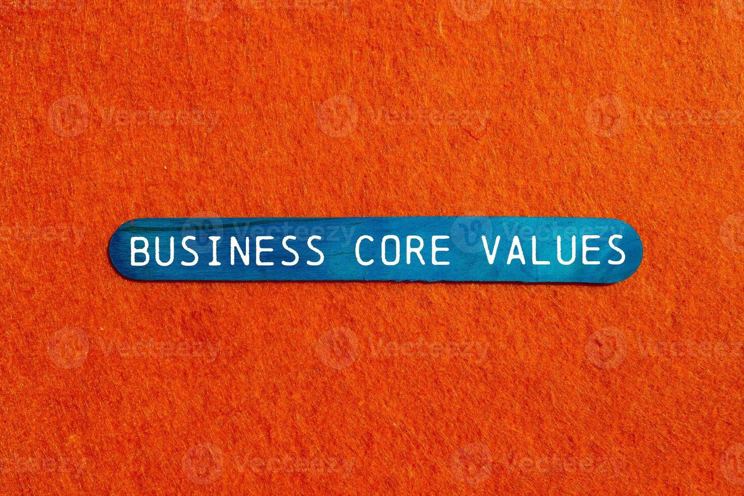 Business core values message written on blue wooden stick on orange background. Conceptual business core values symbol. Copy space. photo
