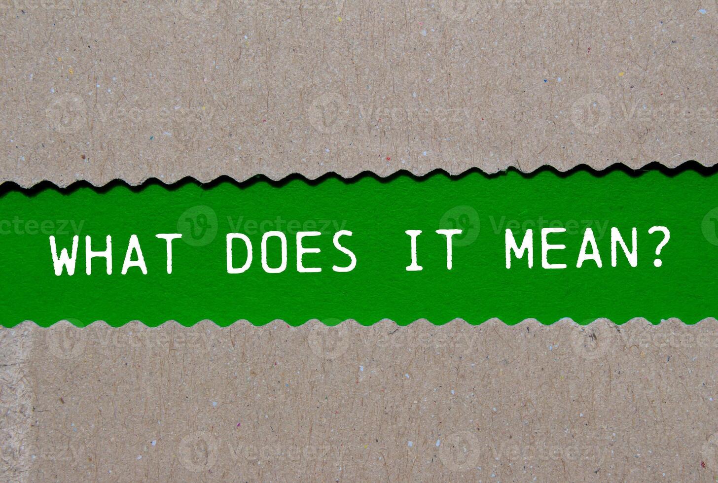 What does it mean question written on ripped torn paper on green background. Conceptual what does it mean question symbol. Copy space. photo