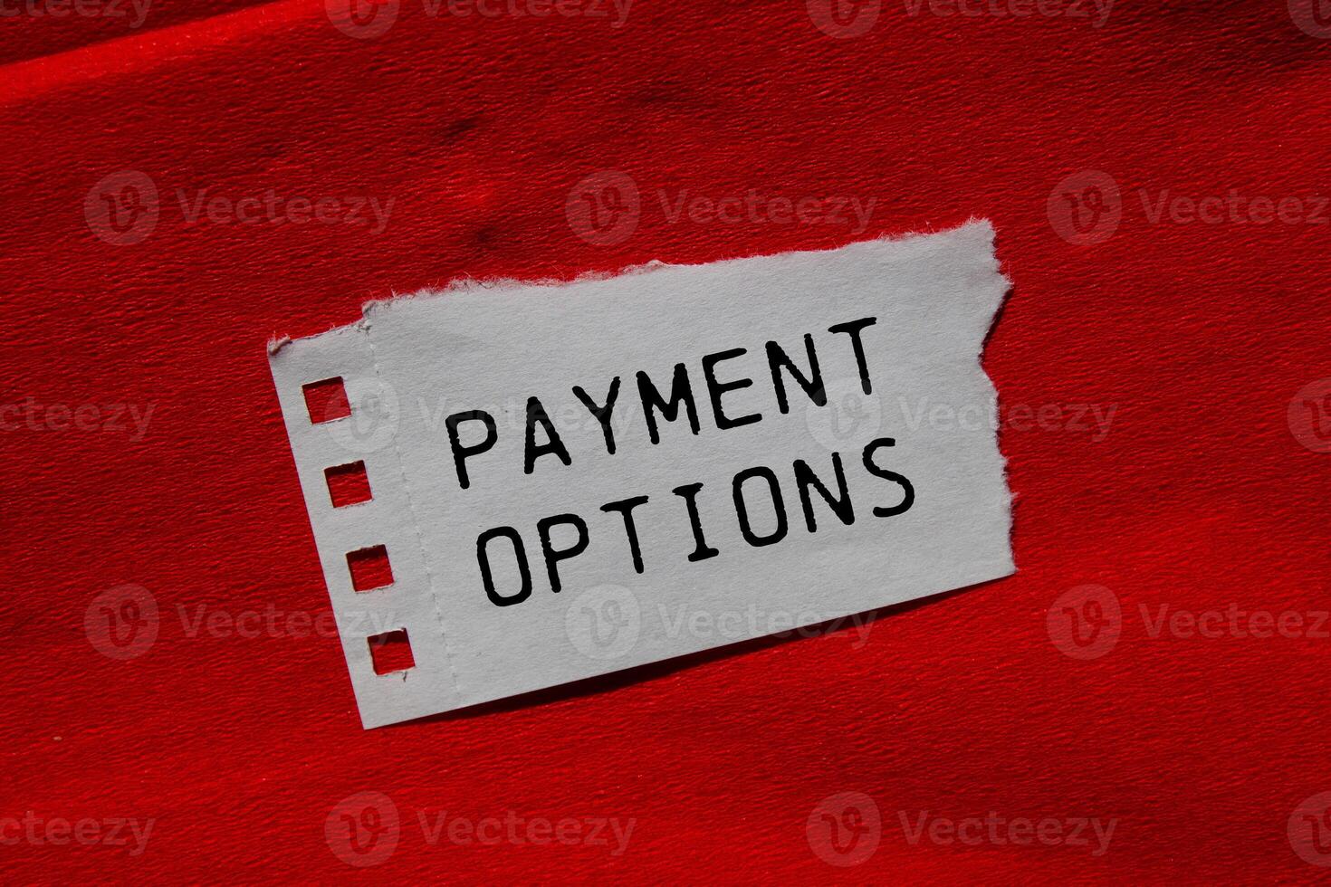 Payment options message written on ripped torn paper piece on red background. Conceptual payment options symbol. Copy space. photo