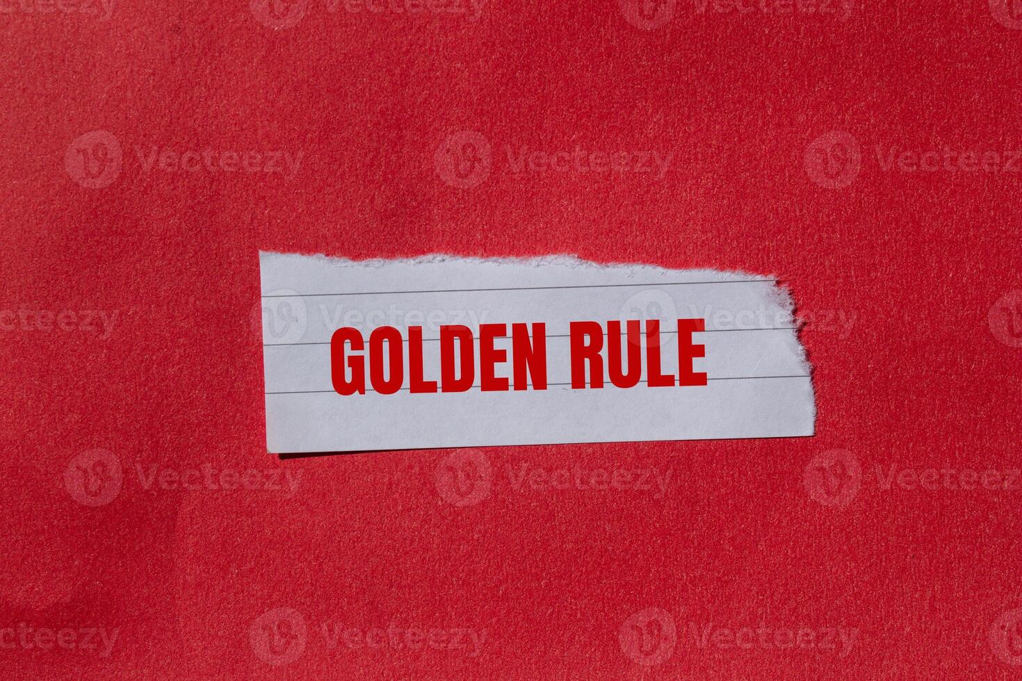 Golden rule message written on ripped torn paper piece with red background. Conceptual golden rule symbol. Copy space. photo