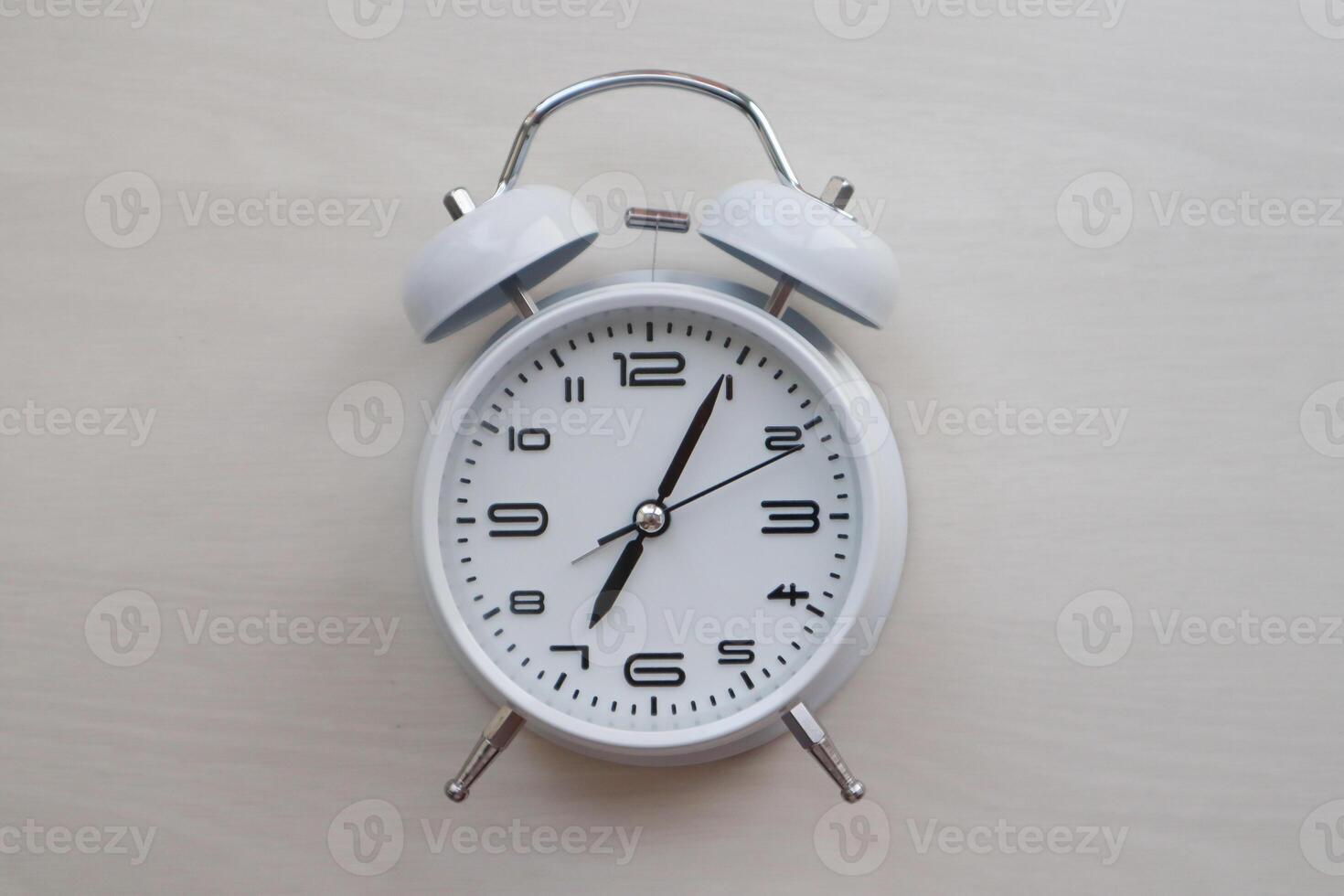 White retro alarm clock on textured background with copy space. Clock face. photo