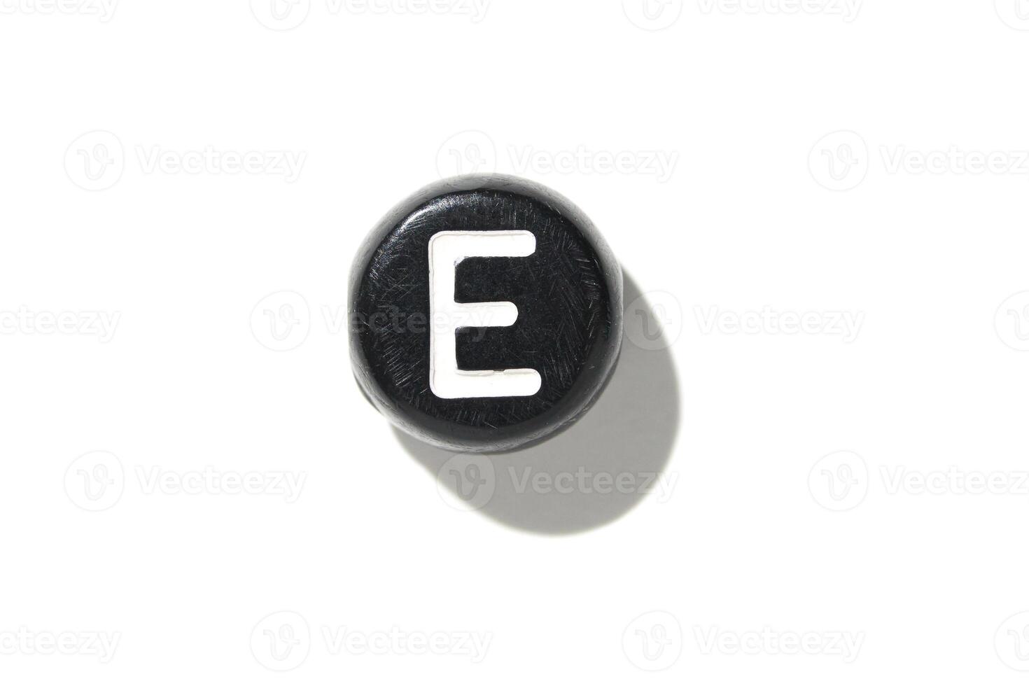 Close-up of vintage typewriter key with letter e on white background featuring shadow and texture photo