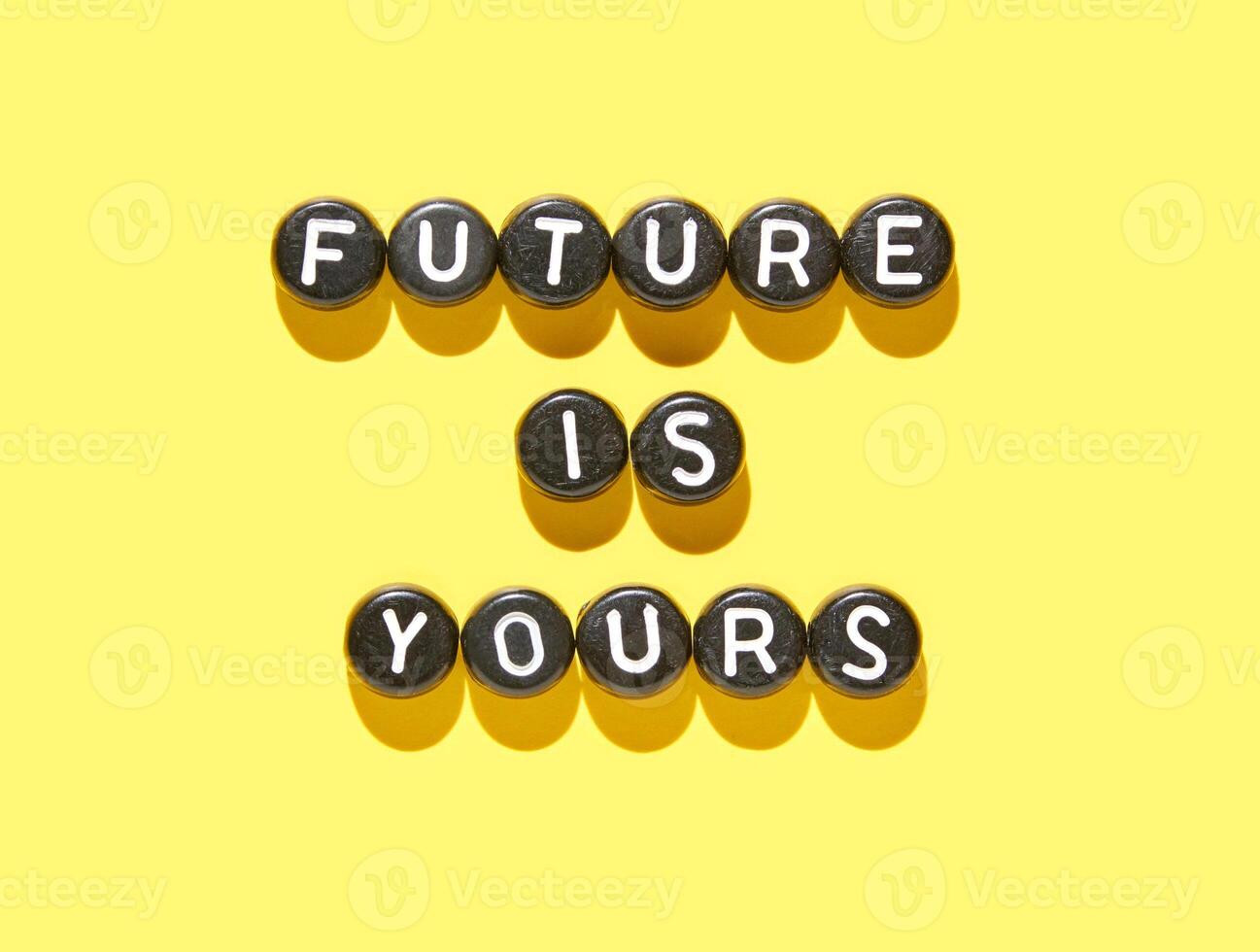 Inspirational alphabet beads on yellow background with future is yours message in bold letters. photo
