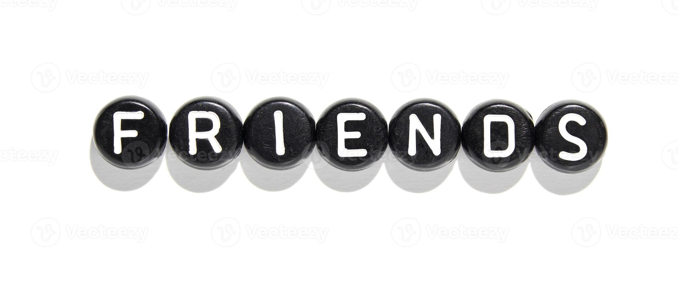 Friends concept with black and white letter beads spelling friendship on a white background photo