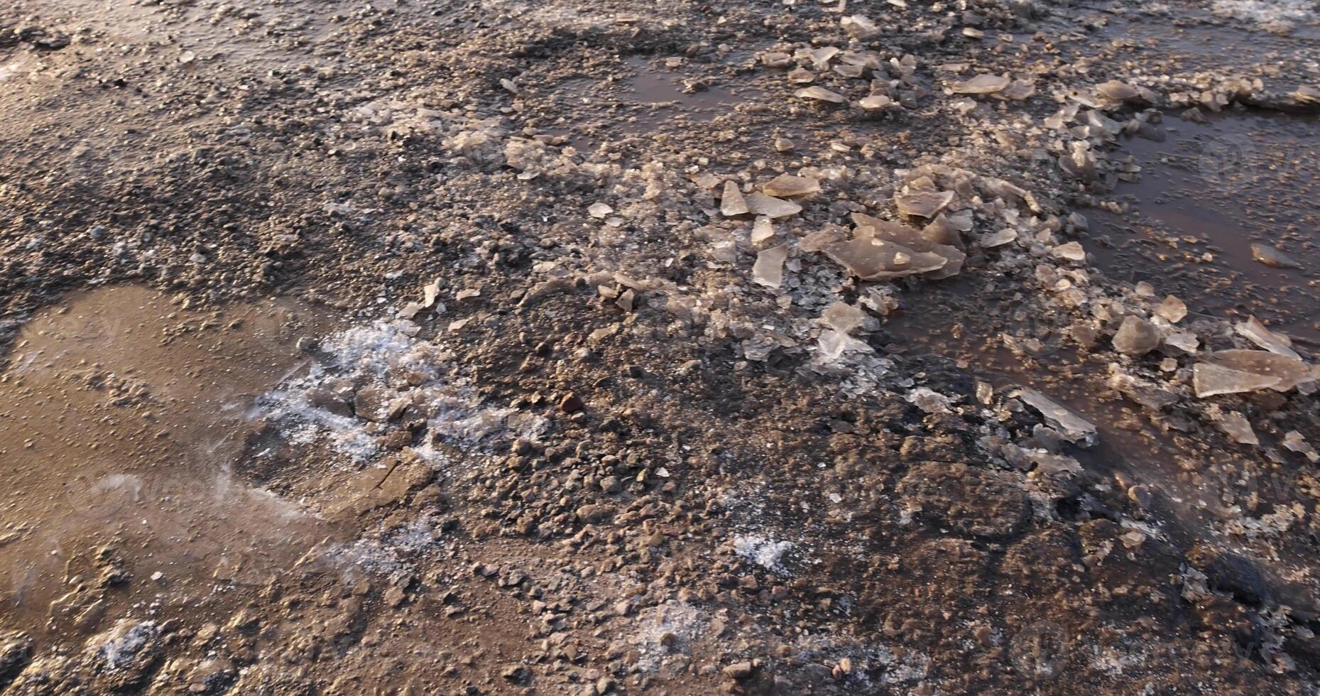 a large number of holes and dirt on the highway in winter photo
