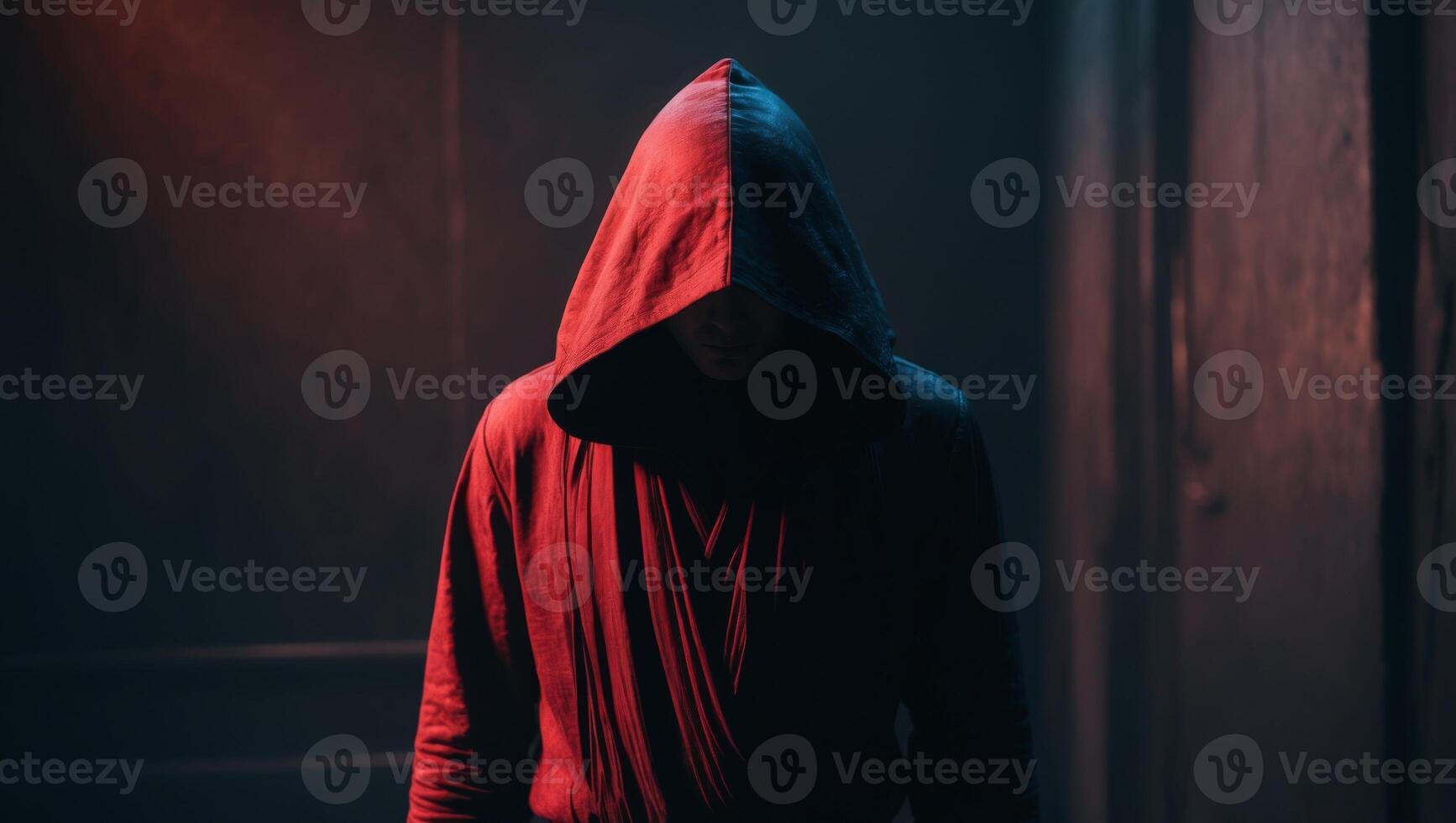 A man in a hooded robe standing in a dark room photo