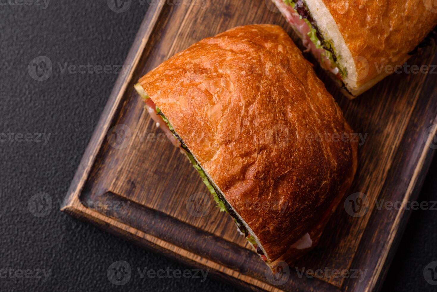Ciabata with jamon or prosciutto, tomatoes, cheese and lettuce photo