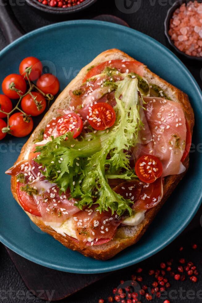 Ciabata with jamon or prosciutto, tomatoes, cheese and lettuce photo