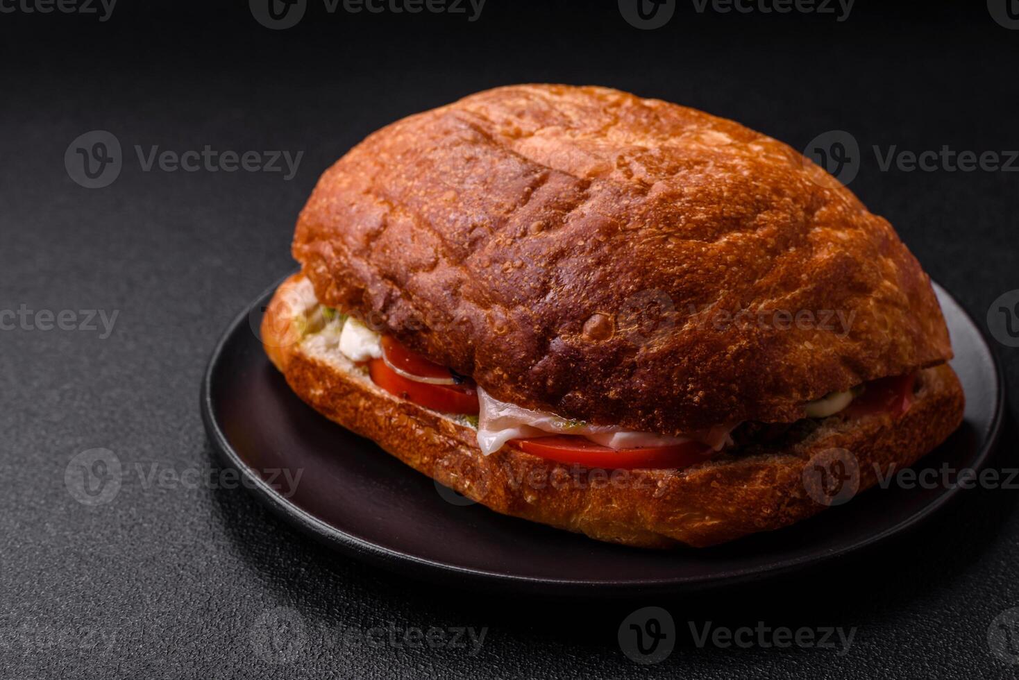 Ciabata with jamon or prosciutto, tomatoes, cheese and lettuce photo