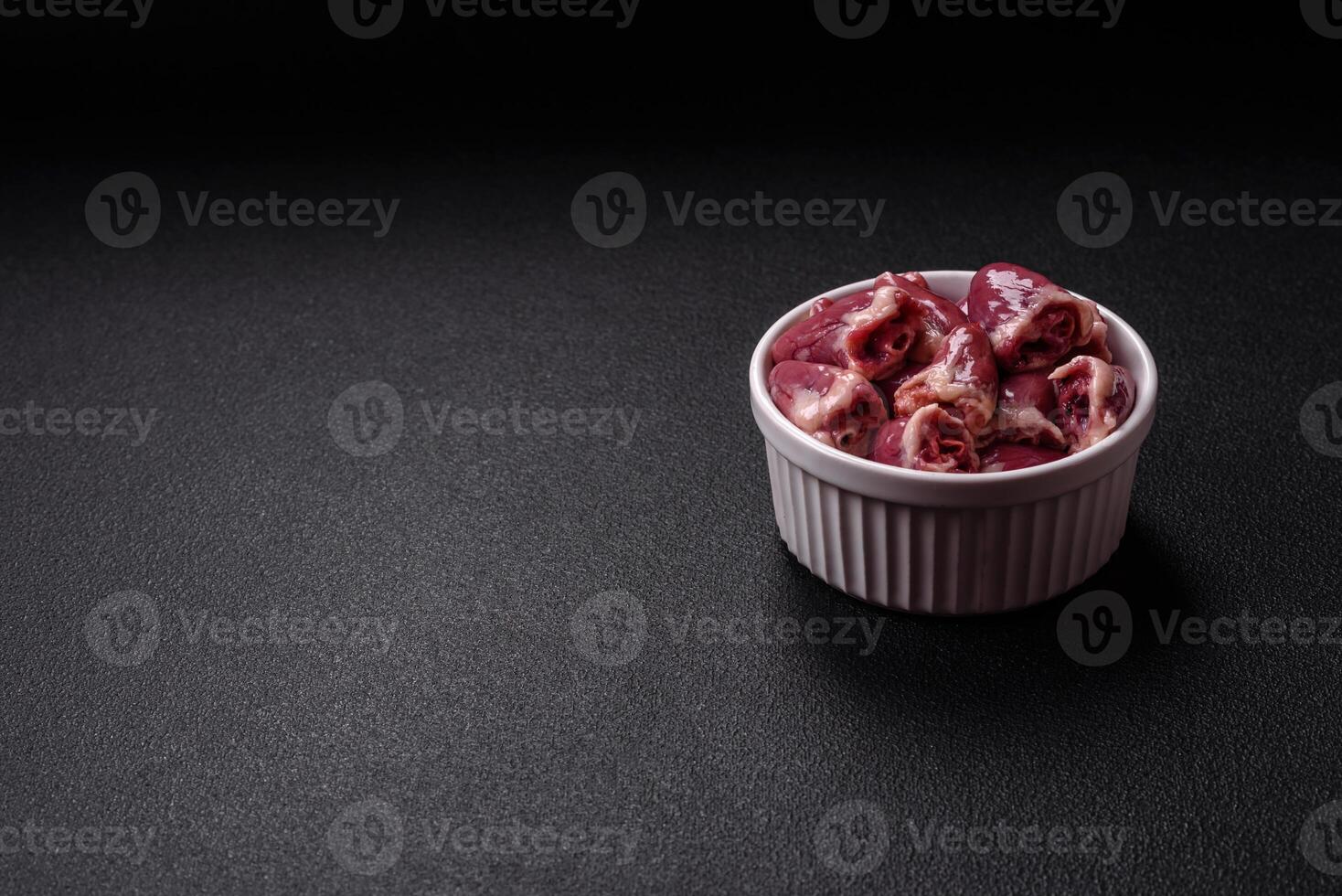 Raw chicken hearts with salt, spices and herbs photo