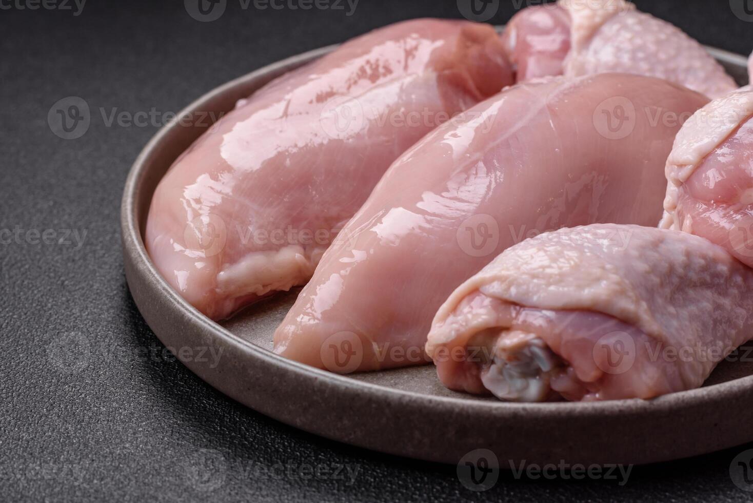 Pieces of raw chicken or turkey fillet with salt, spices and herbs photo