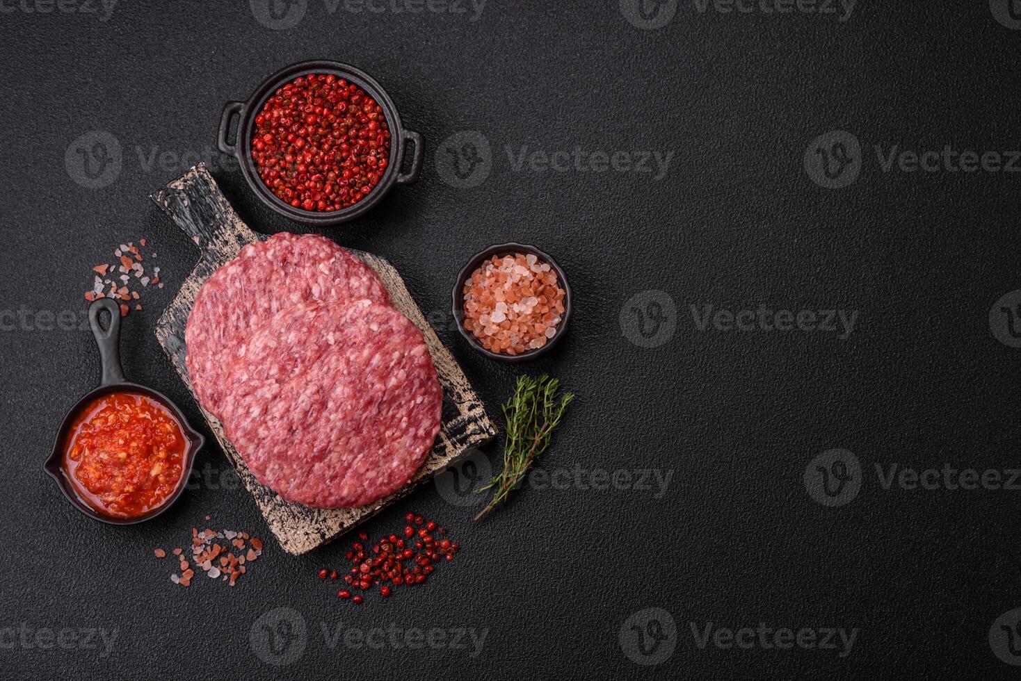 Fresh raw ground beef burger patty with salt and spices photo