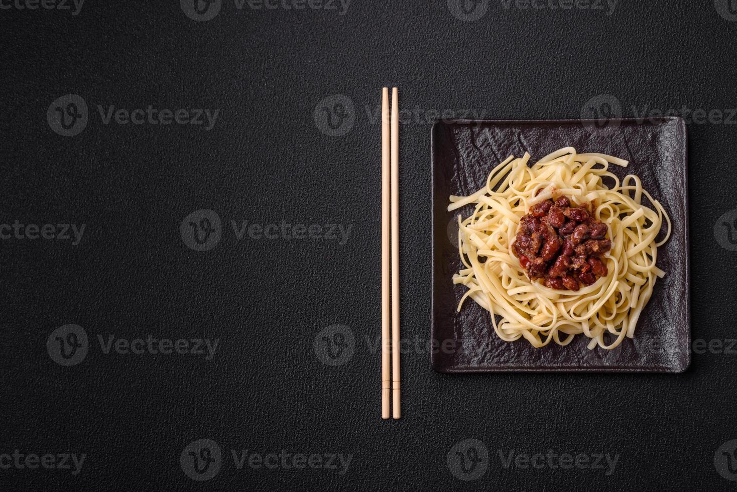 Rice noodles with beans, meat, tomato sauce, spices and herbs photo