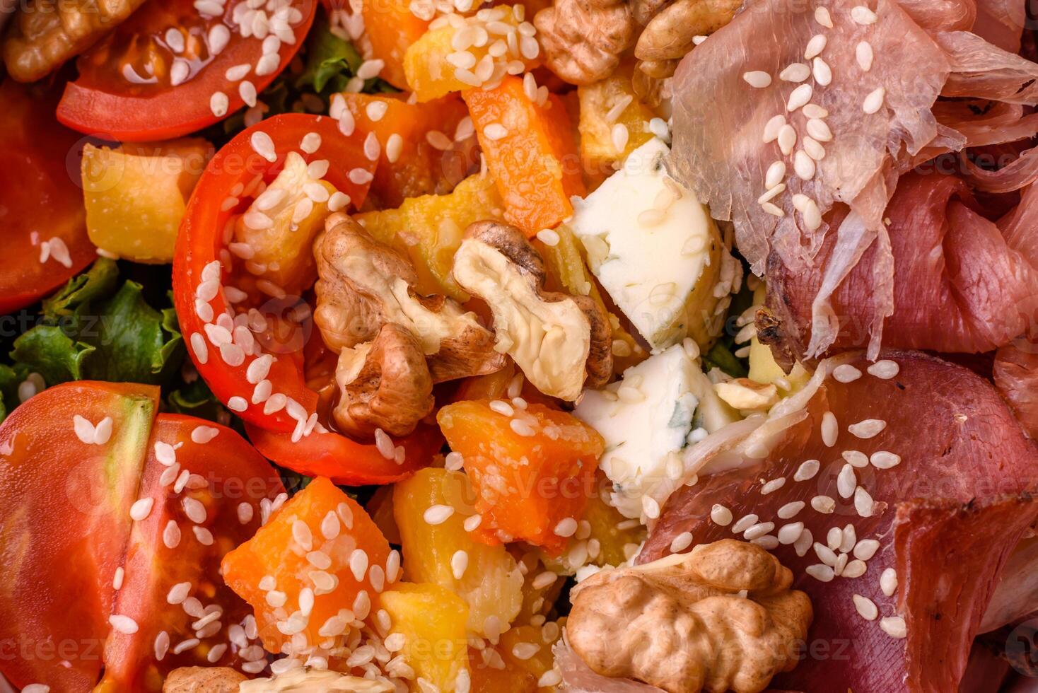 Appetizing salad with prosciutto, pumpkin, cheese and tomatoes photo