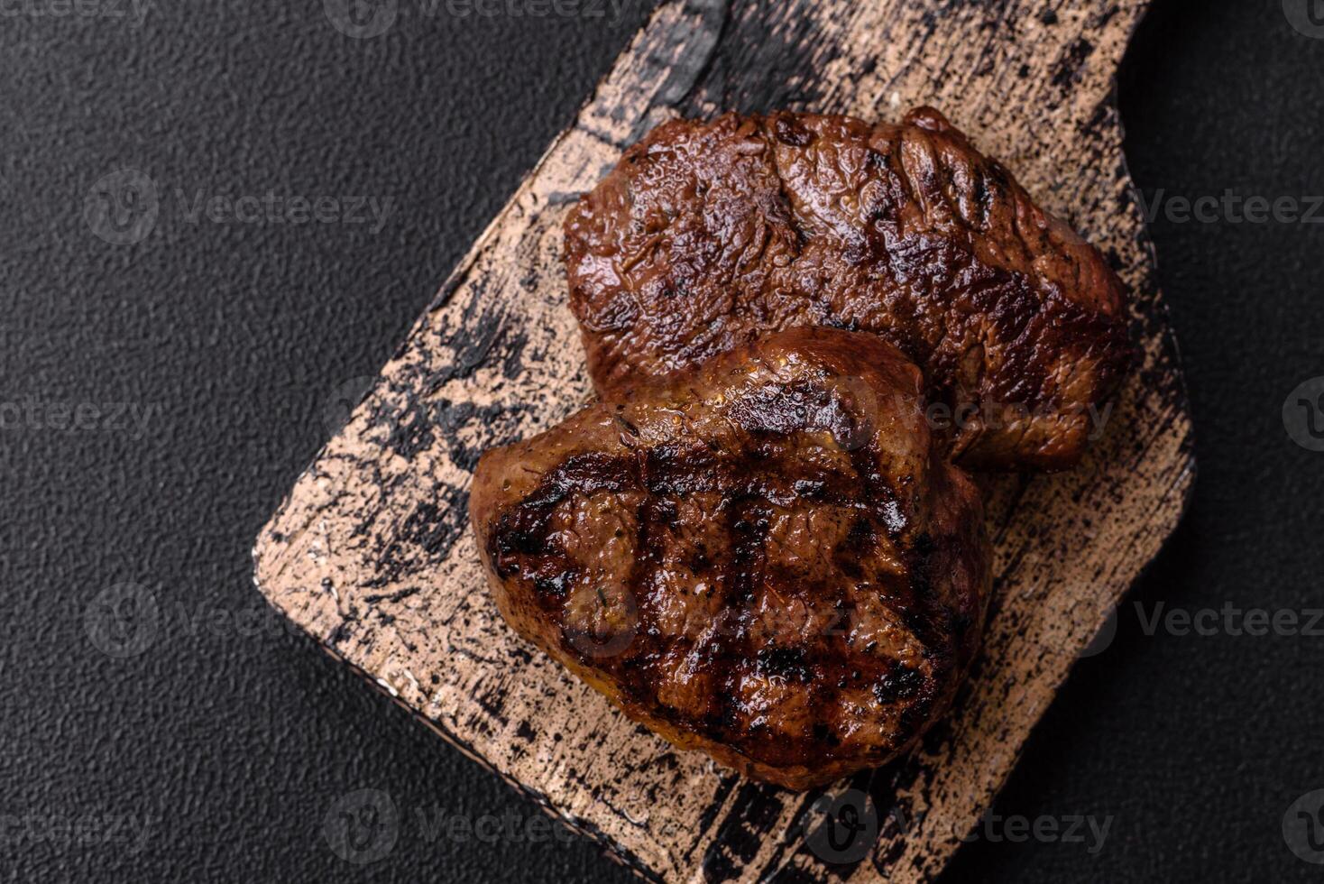 Juicy beef steak baked on the grill with salt, spices and herbs photo