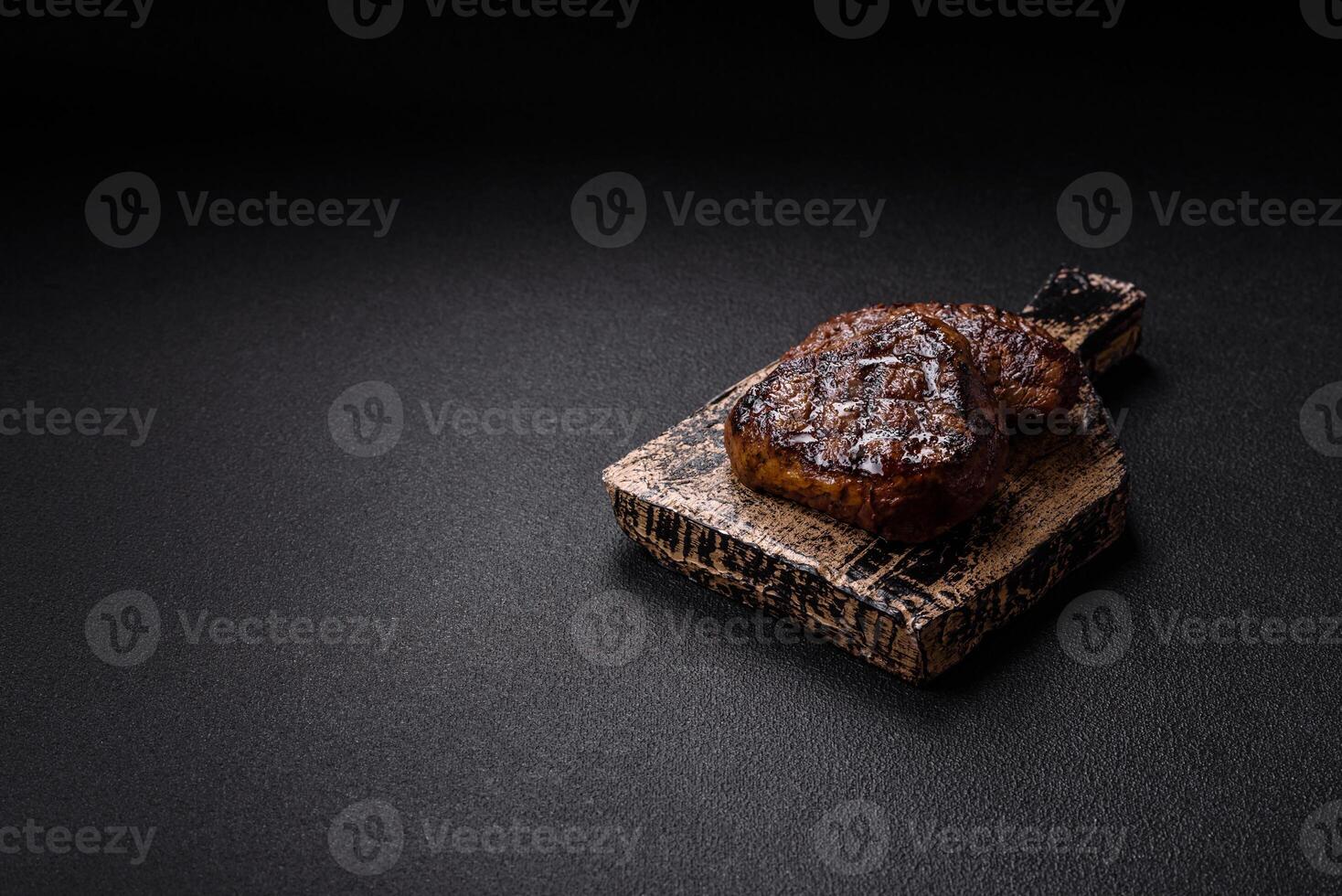 Juicy beef steak baked on the grill with salt, spices and herbs photo