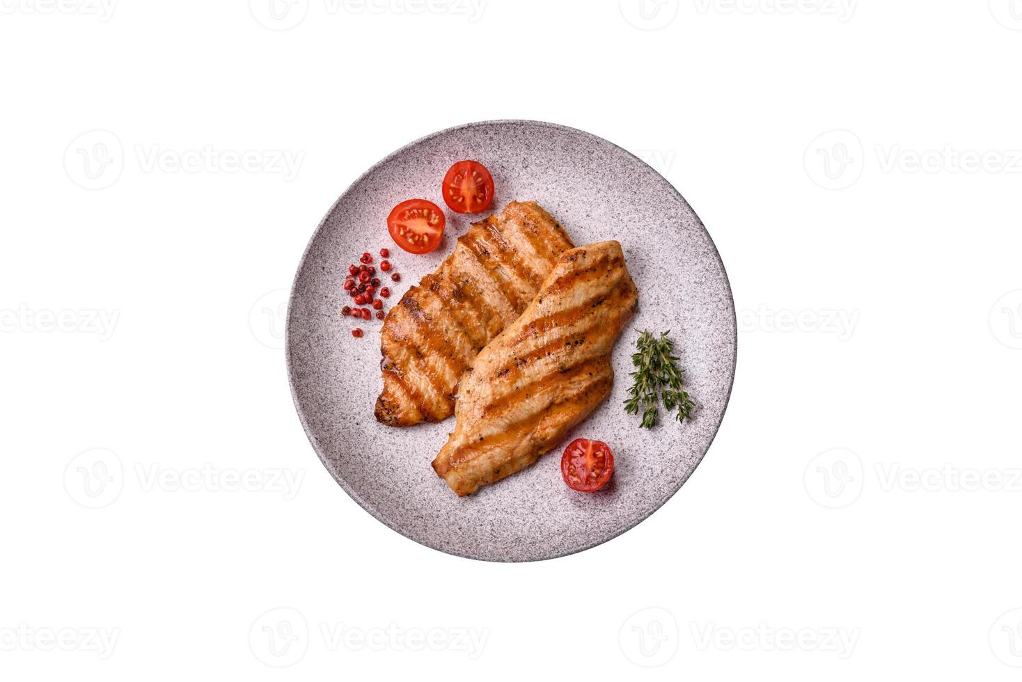 Juicy chicken fillet baked on the grill with salt, spices and herbs photo