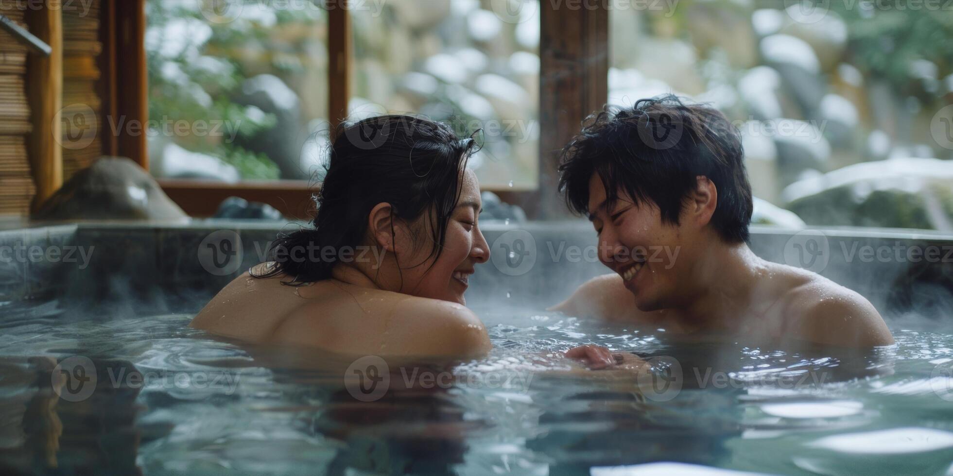 A couple cuddled up together in a hot spring but occasionally sneaking away to the nearby cold spring for a refreshing jolt photo
