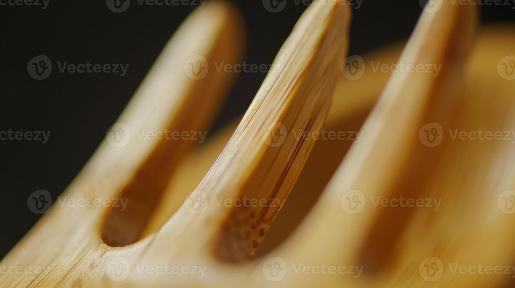 A zoomedin shot of a bamboo fork revealing the smooth and polished surface of the utensil. Each tine has a slight curve creating a gentle yet effective scooping shape photo
