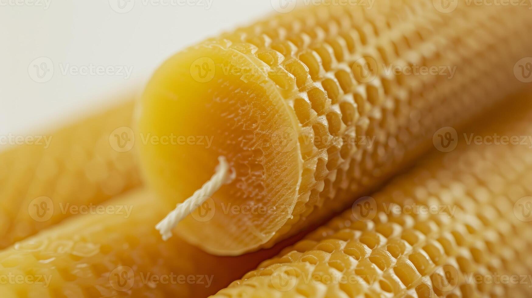 A detailed shot of a large handrolled taper candle made from pure organic beeswax showcasing the fine ribbed texture and slight sheen from the natural wax photo