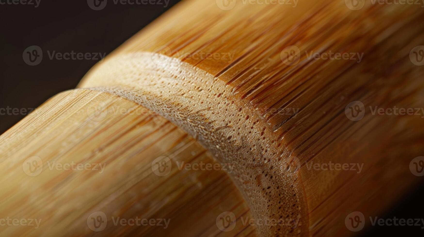 A closeup of a bamboo rolling pin revealing the smooth and cylindrical shape of the utensil. The natural variations in color and texture give it a unique and organic look photo
