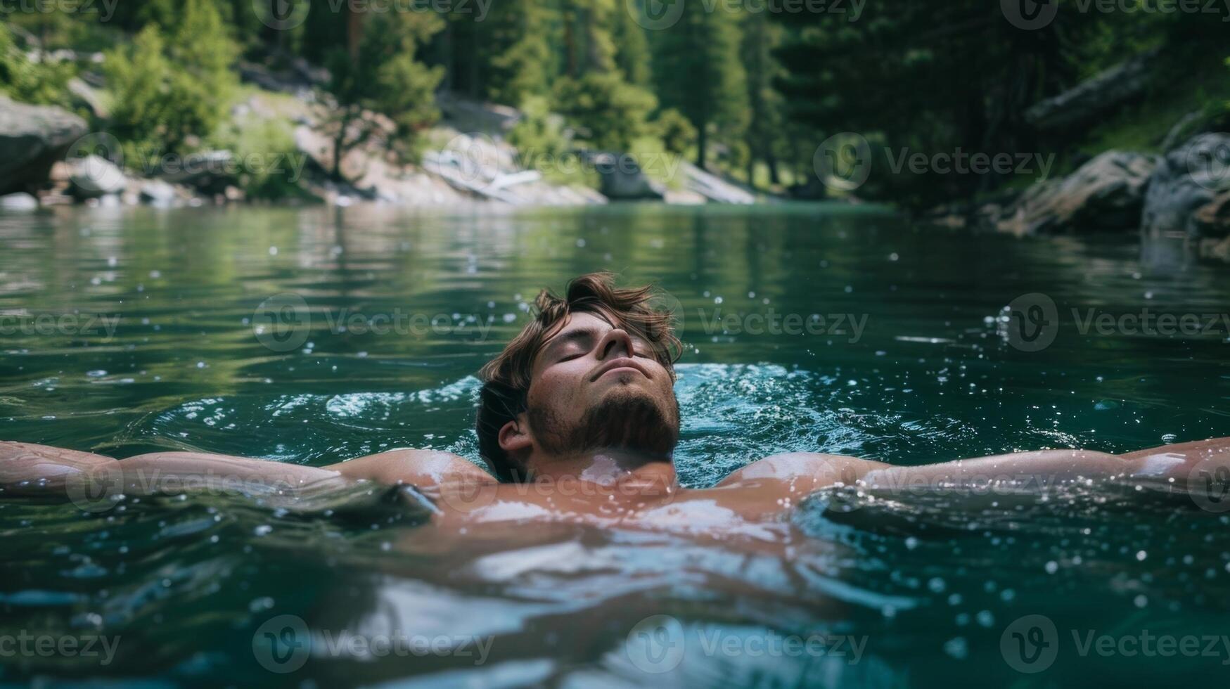 A man floating on his back in a tranquil lake relishing the feeling of cool water rushing over his body and lulling him into a state of relaxation photo