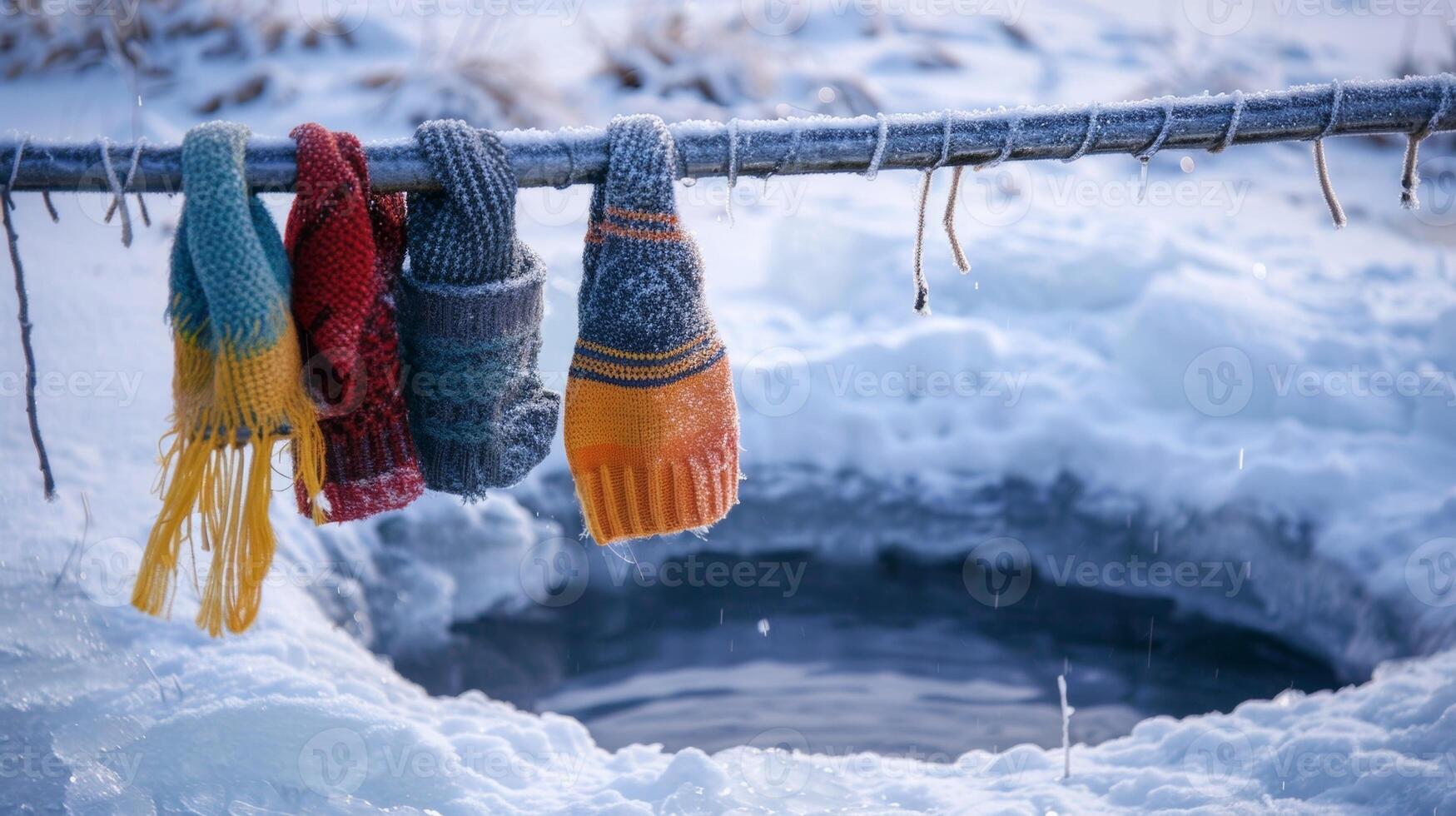 A pair of gloves hat and scarf hanging on hooks next to a hole out of a frozen lake indicating that the winter ice bath challenge is about to begin photo