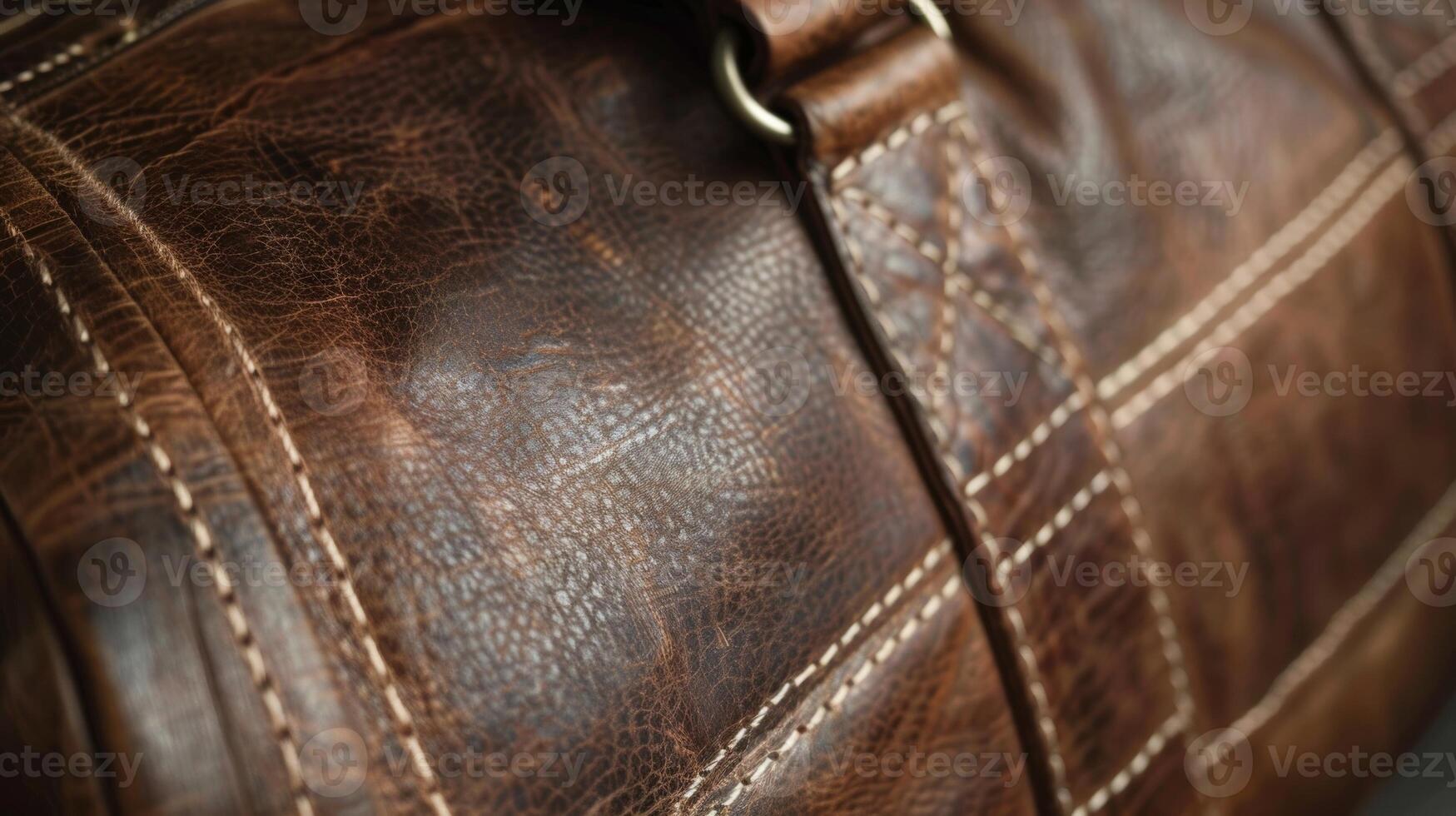 A closer look at a leather duffel bag reveals the strength and durability of the material. The grain is tightly packed and the stitching is done with thick reinforced thread to ensur photo