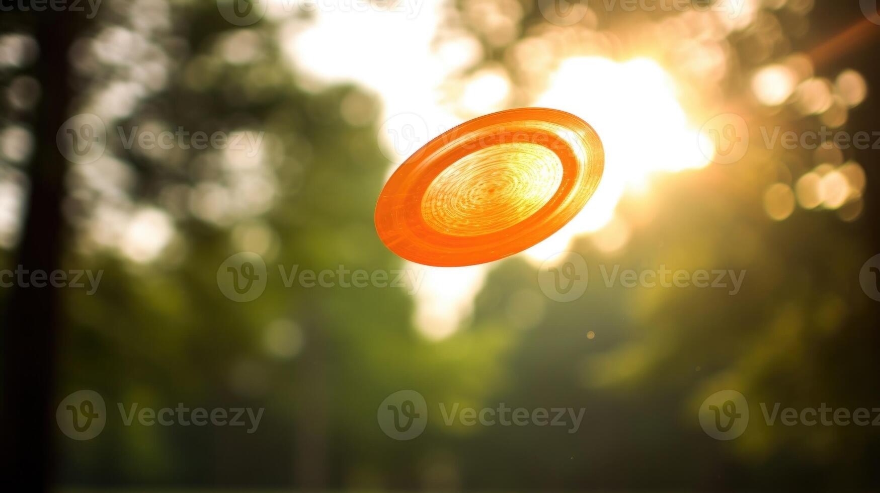 Closeup of a bright orange disc flying through the air during a game of ultimate frisbee. photo