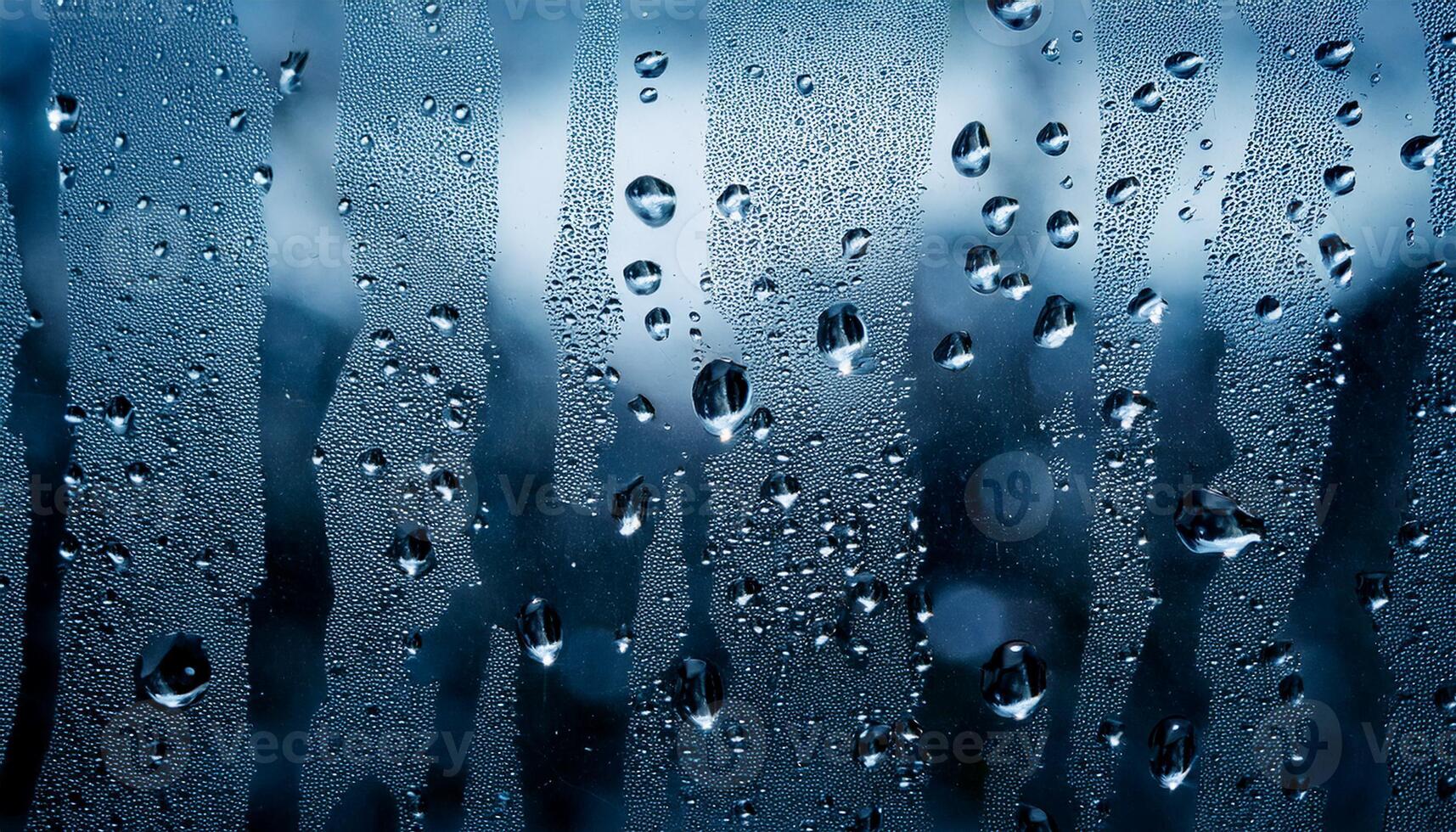 Close-up of water droplets on a foggy glass window with streaks, creating a cold, abstract, and textured background. photo