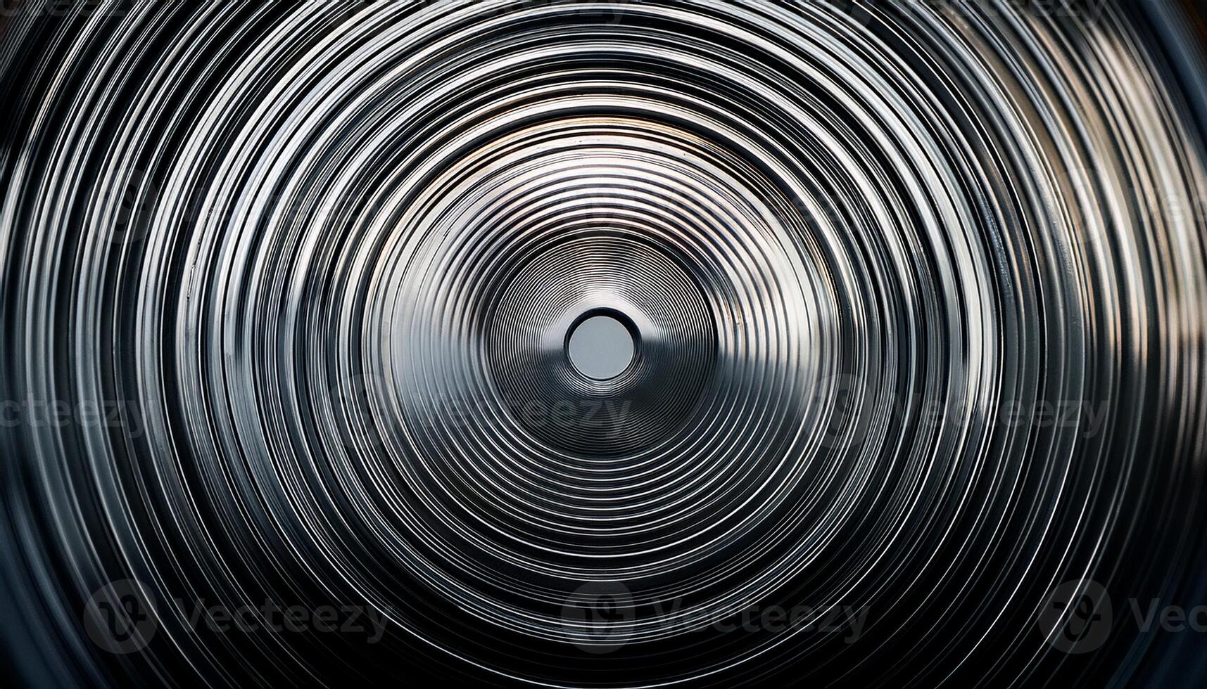 Close-up of abstract metallic concentric circles forming a radial pattern, creating a hypnotic, industrial design with reflective surfaces. photo