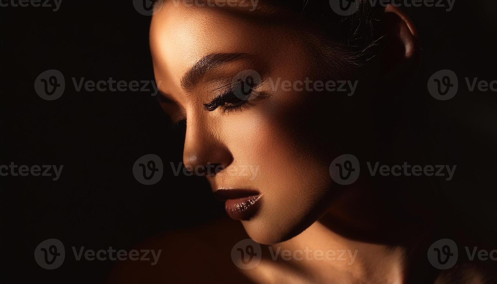 Close-up portrait of a woman with downcast eyes in dramatic lighting, casting soft shadows across her face for an artistic effect. photo