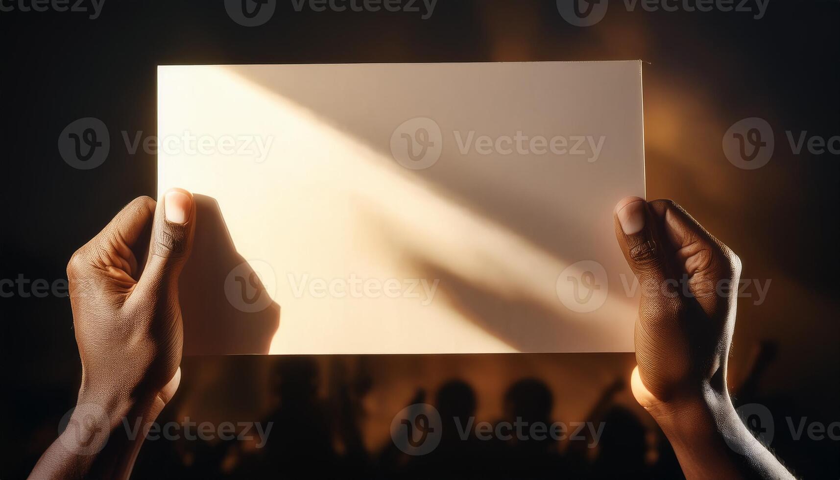 Two hands holding a blank card with dramatic lighting and shadow, creating a mysterious and contemplative atmosphere. photo