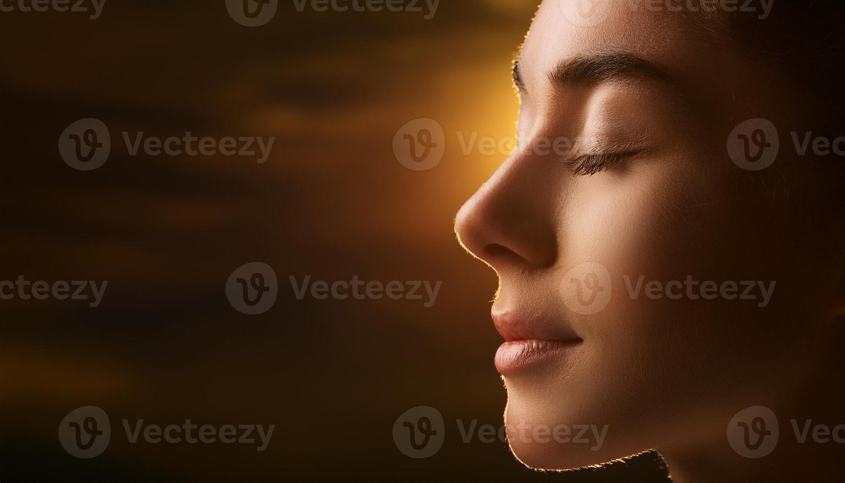Close-up profile of a young woman with closed eyes, radiating peace and calm, against a warm, soft-focus background. photo