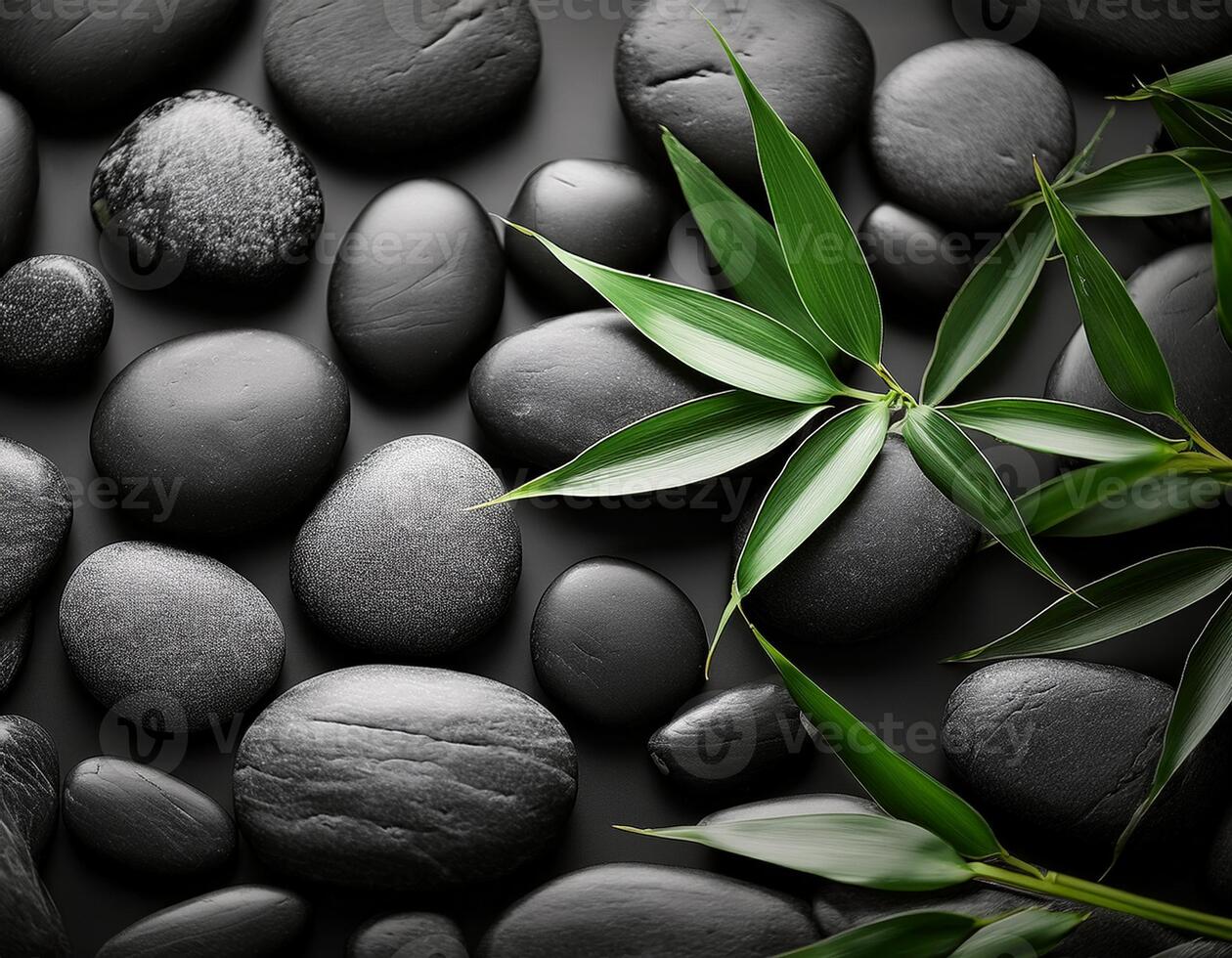 A serene arrangement of smooth black stones and fresh green bamboo leaves, symbolizing relaxation, balance, and tranquility. photo