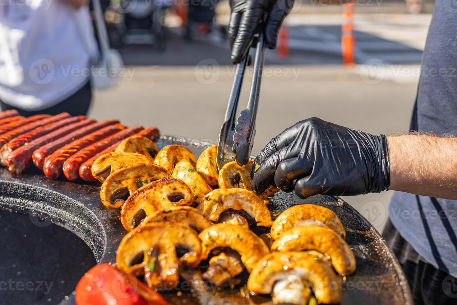 Variety of food being cooked on a grill. The food includes shrimp, corn on the cob, and flatbreads, which are all being cooked over an open fire. The food is being cooked in a round metal pan. photo