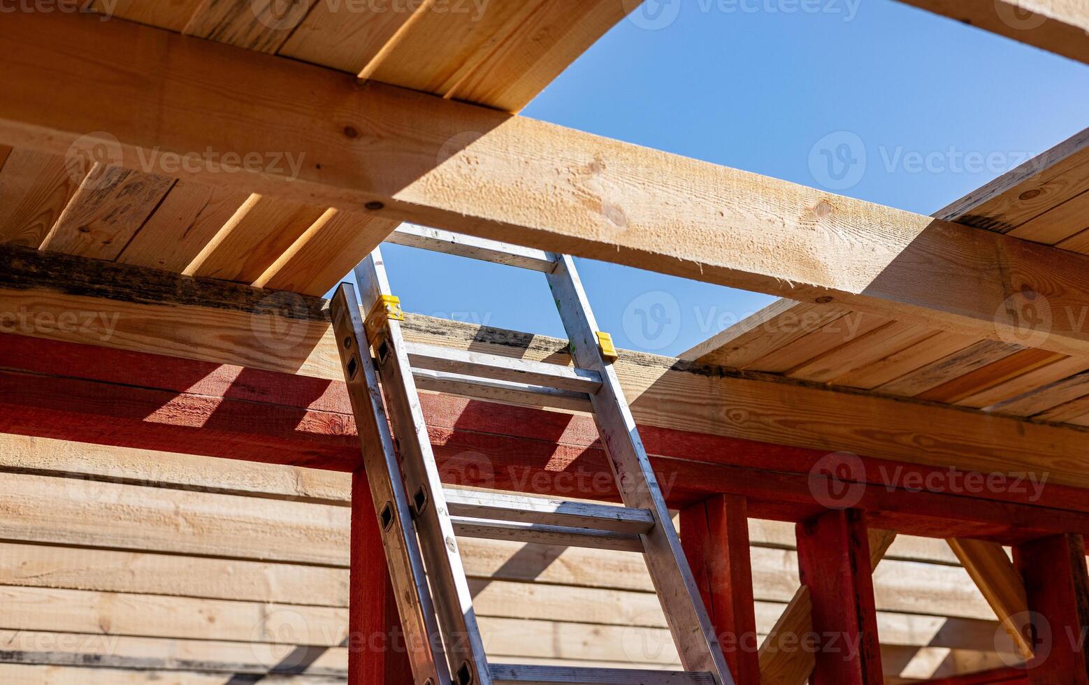 Under-construction residential wooden frame home located near a forest. Commencement of a new construction project for a cozy house or a mountain cottage. Idea of contemporary ecological construction. photo