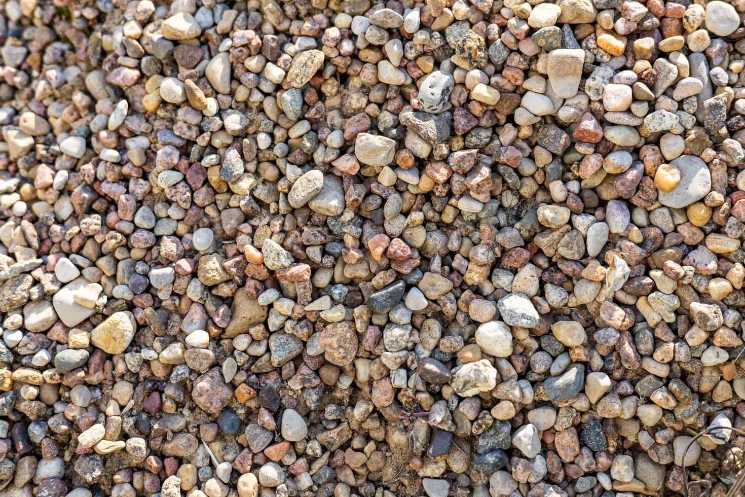 Close-up of a gravel surface. The stones are densely packed together, creating a textured and rough surface. photo