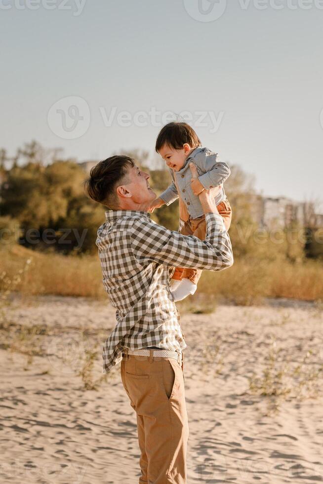Portrait of loving father and his one years old son walking and playing outdoors photo