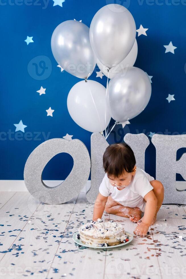curious baby boy poking finger in his first birthday cake photo
