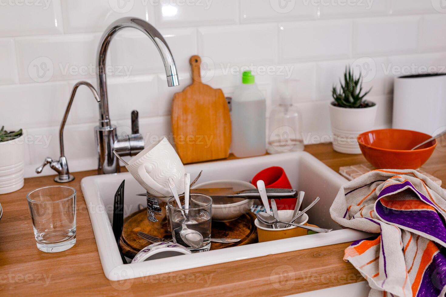 Clutter, dirty dishes by the sink in the white kitchen photo