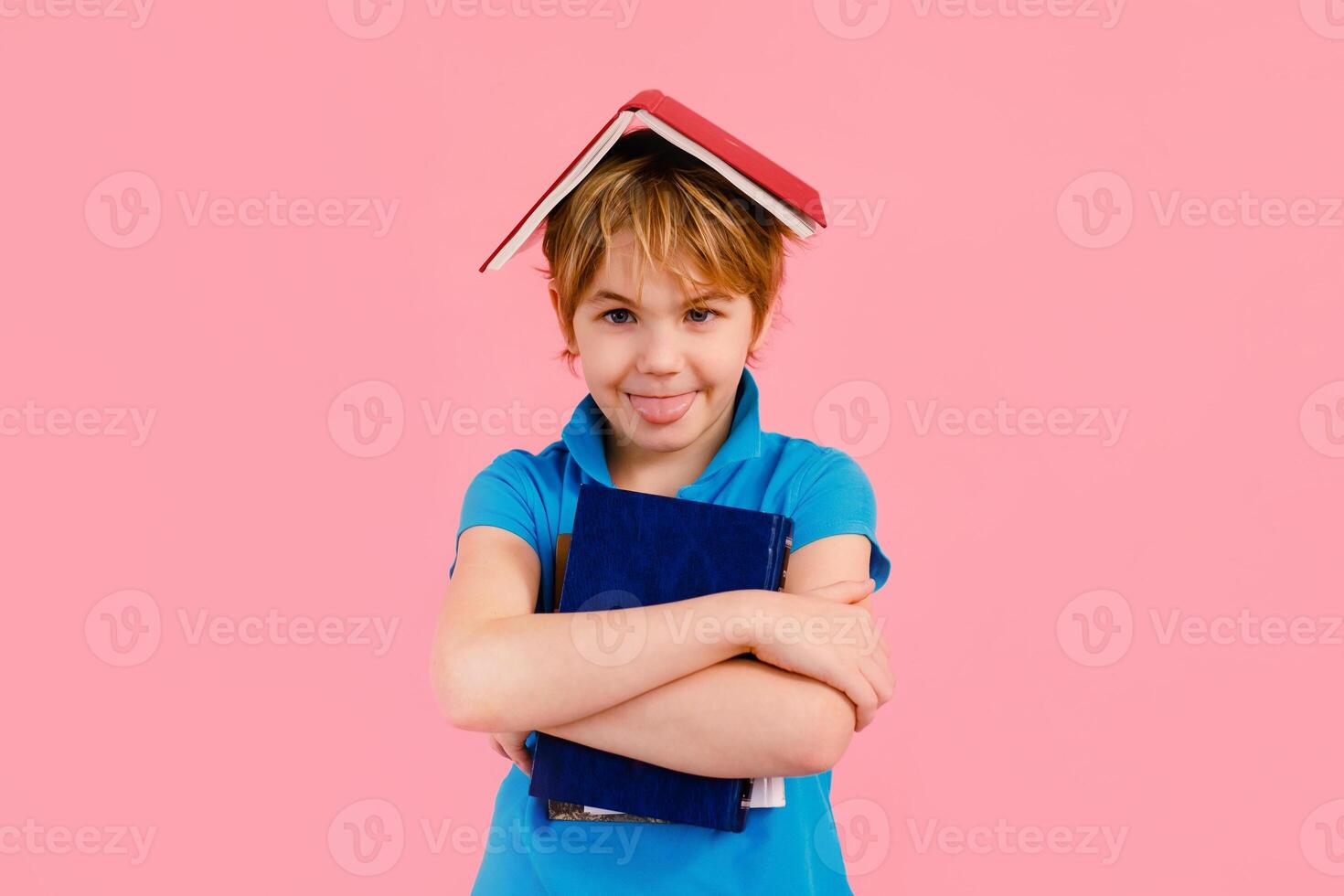 Blonde boy in t-shirt reading a book thirsty for knowledge on pink background. photo