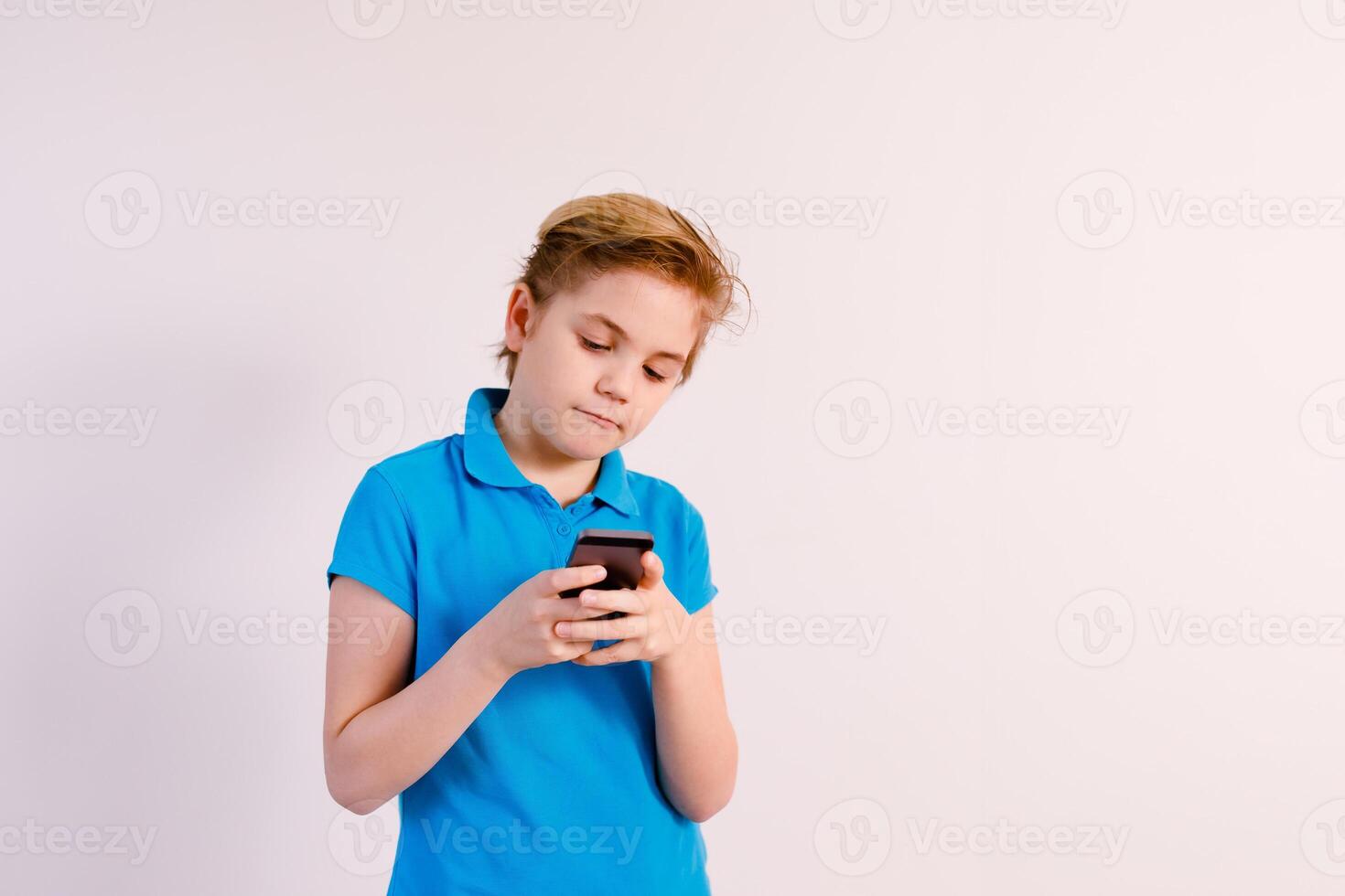 Little boy in glasses using a tablet computer with a light background photo