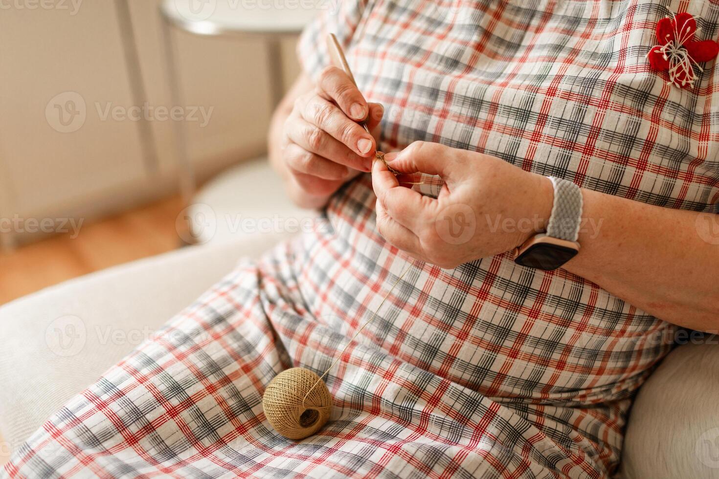 Hands of a senior woman crocheting captured in close-up photo
