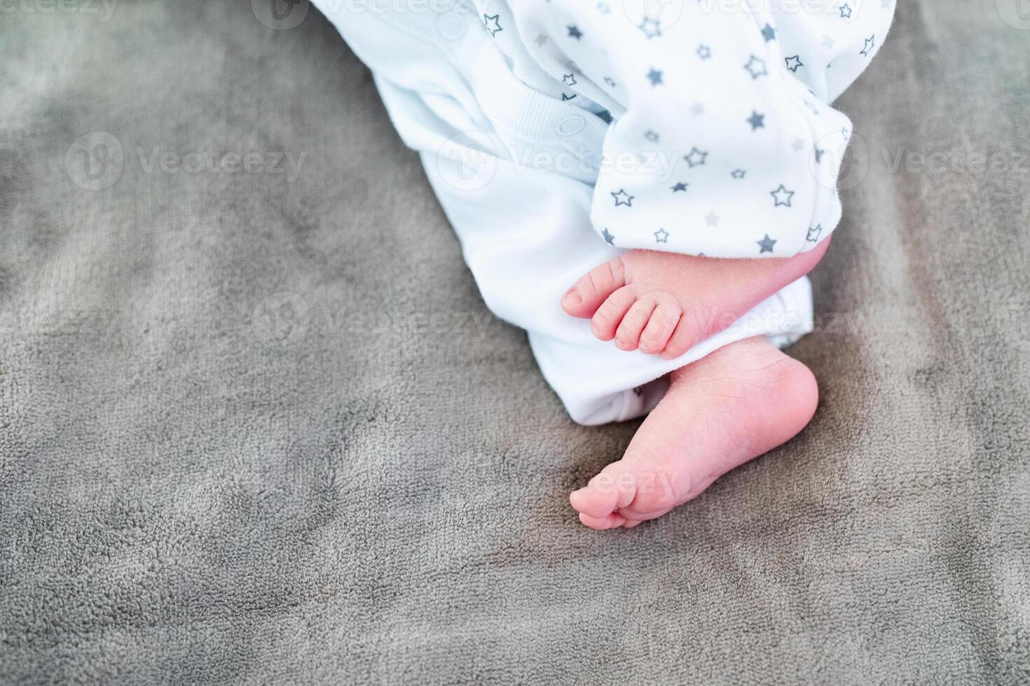 Newborn baby on a white blanket - tiny baby feet closeup photo