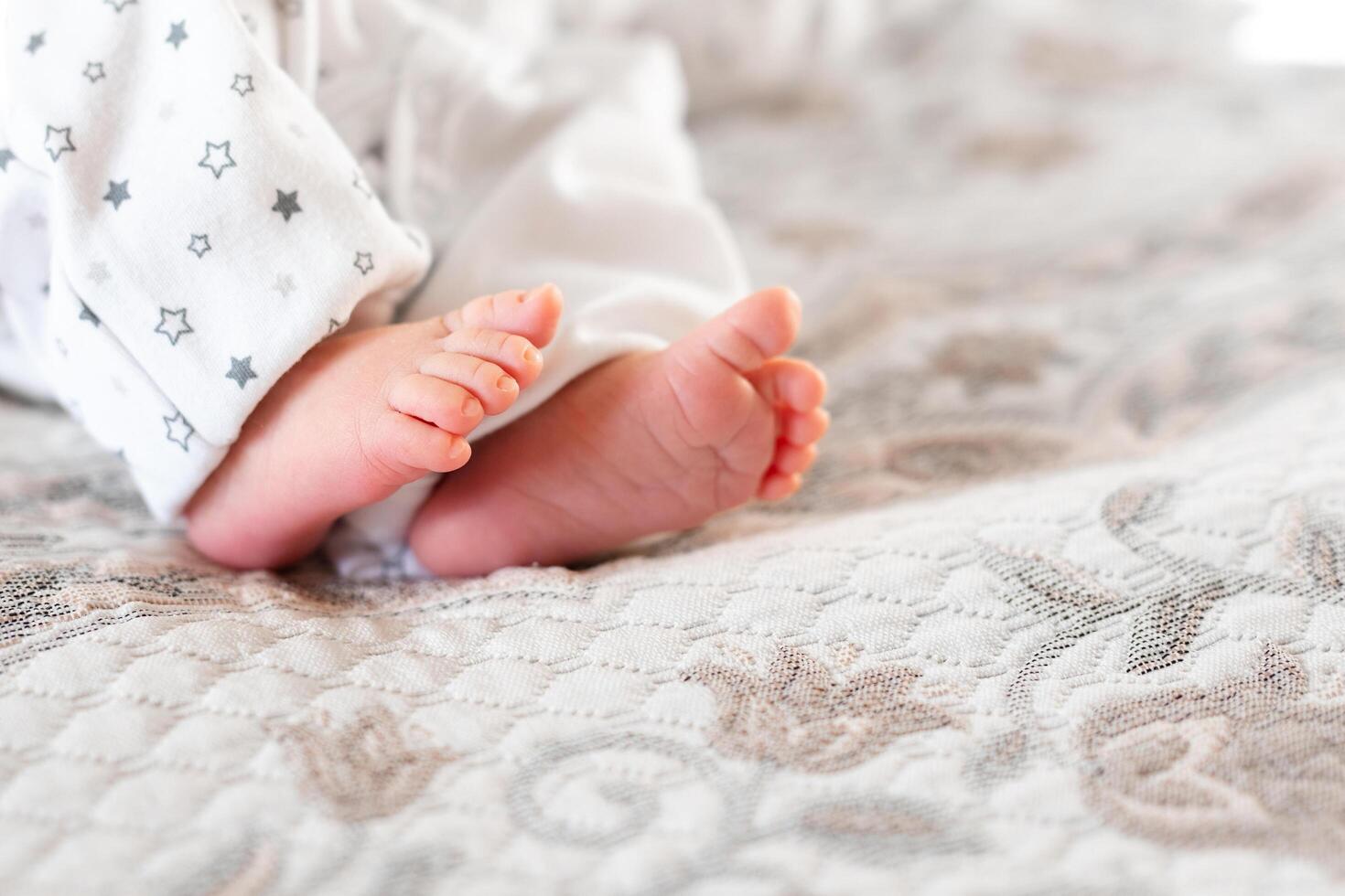 Newborn baby on a white blanket - tiny baby feet closeup photo