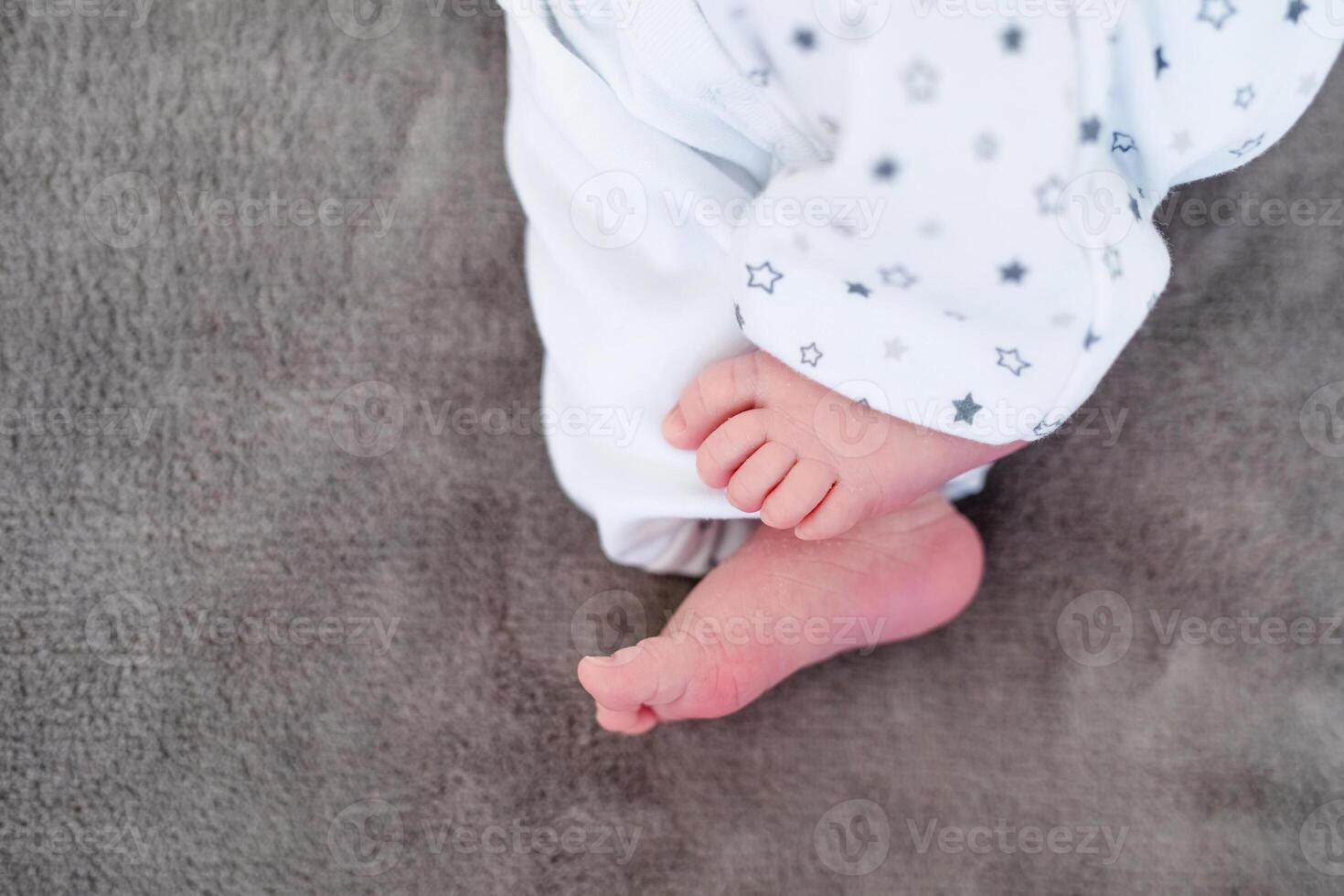 Newborn baby on a white blanket - tiny baby feet closeup photo