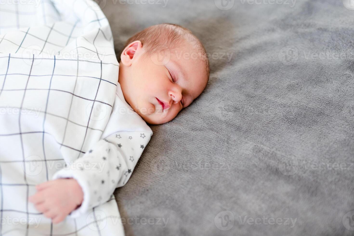 Close-up portrait of adorable baby boy sleeping in bed, 1 year old baby concept photo